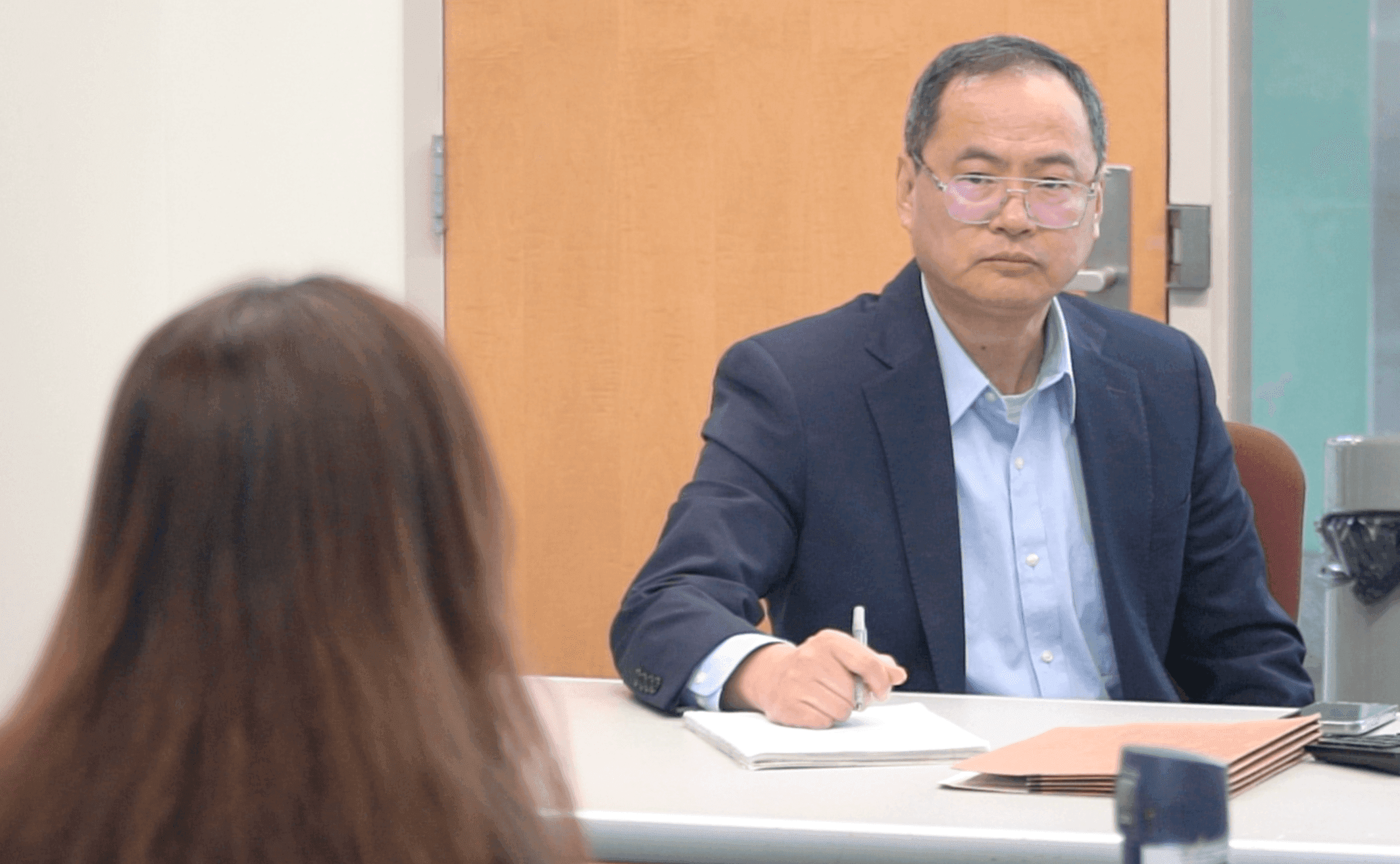 Ming Li(Right) is discussing education schedules with his colleague at Howard County Chinese School. (Photo by: Pingping Yin)